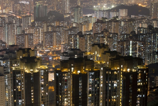 A long exposure shows apartment buildings and office blocks clustered tightly together in vivid detail in Hong Kong's Kowloon district. 