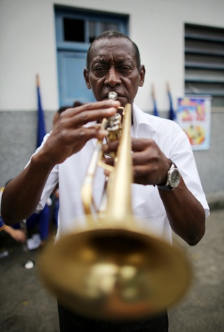 Maestro Couto pauses to have his portrait taken before playing in a procession near the Nossa Senhora da Penha Church on the final day of the annual October feast of the patron saint in Rio de Janeiro, Brazil.