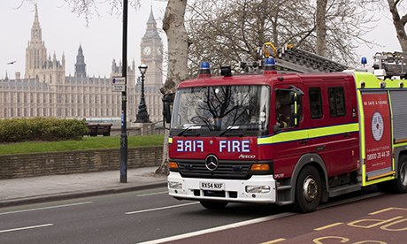 London a fire engine speeds by UK Parliament
