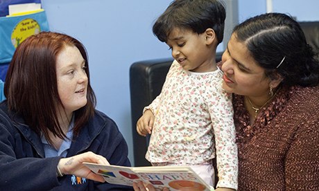 two volunteers reading with nursery child
