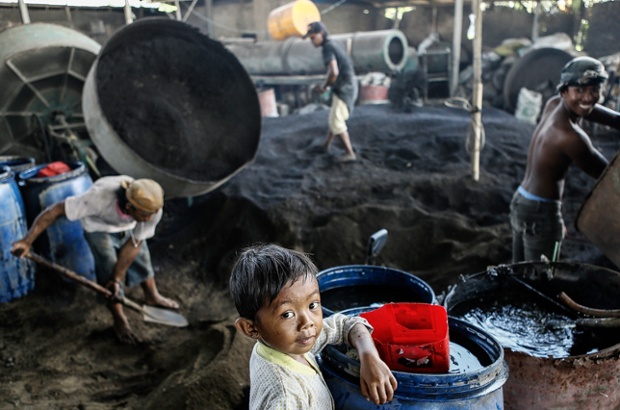 A worker's son poses for a picture at the Temesi recycling plant in Temesi Village, Gianyar, Bali, Indonesia.