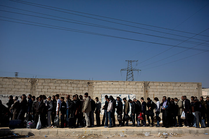 Syrian men queue at security checkpoint