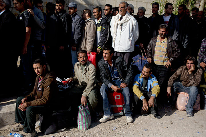 Syrian men wait to be searched