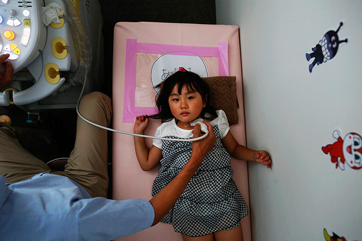 Fukushima: A doctor conducts a thyroid examination on four year old Maria Sakamoto