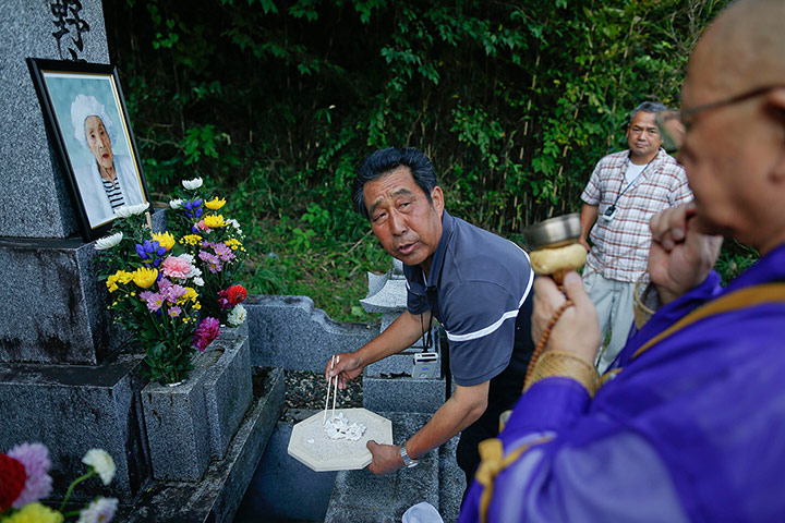 Fukushima: A relative of Yotsuno Kanno puts her remains into a family grave