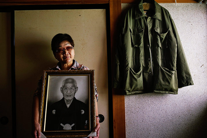 Fukushima: Mieko Okubo, 59, poses with a portrait of her father-in-law Fumio Okubo