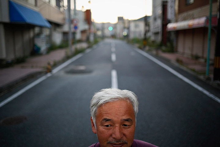 Fukushima: Naoto Matsumura poses for pictures in an empty street 