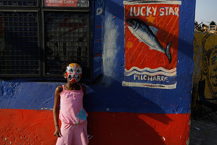 Alexandra Township: A young girl wears a mask