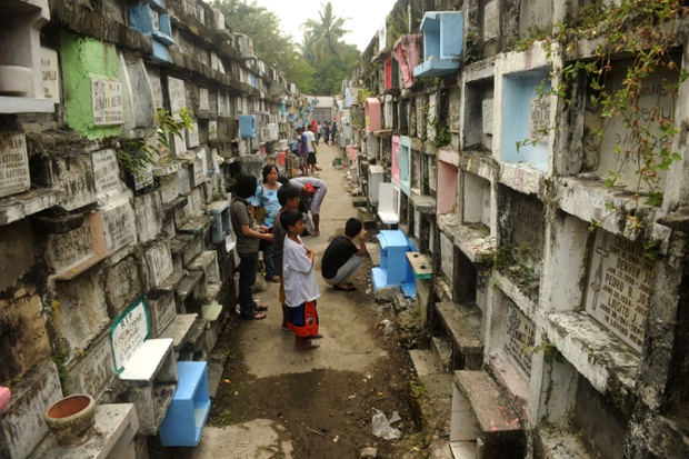 Relatives visit their departed loved ones at a cemetery in Manila, Philippines. Millions of Filipinos will visit cemeteries to pay respects to their dead this week in an annual tradition that combines Catholic religious rites with the country's penchant for festivity.