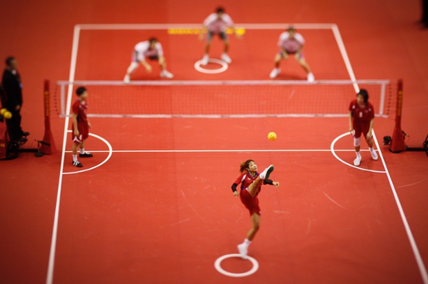 A tilt shift image of Wanwisa Jankaen serving in a  Sepaktakraw  - kick volleyball - match