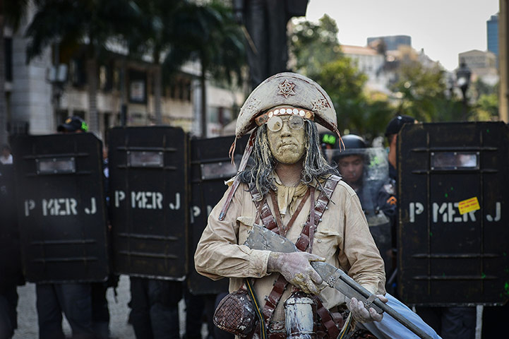 20 Photos: A street performer during a protest by teachers against corruption in Rio