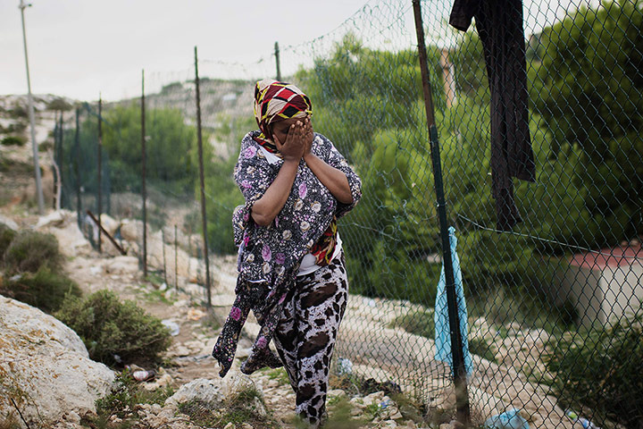 20 Photos: A migrant woman walks outside a temporary refugee camp on Lampedusa