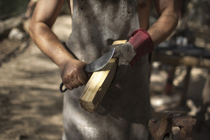 Knights of Jerusalem: A blacksmith checks the sharpness of his knife