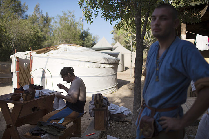 Knights of Jerusalem: Man sews his shirt at the Knights Of Jerusalem Historical Festival
