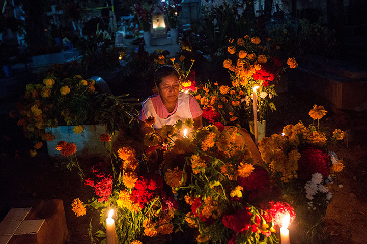 Day of the dead Mexican woman lights a candle