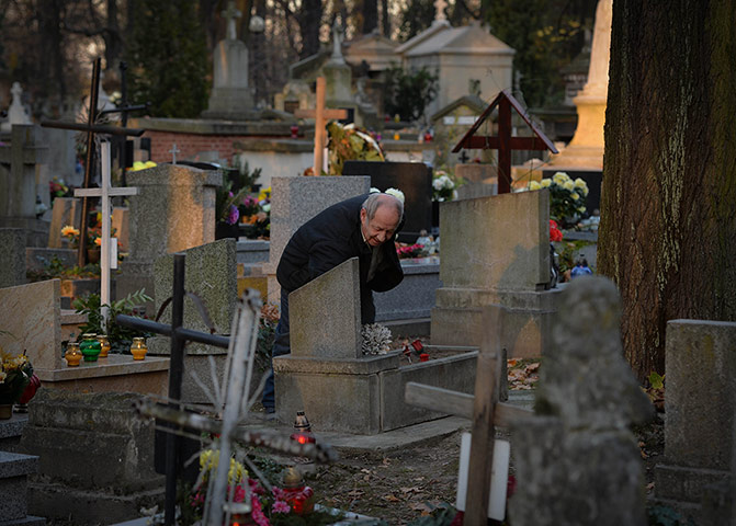 Day of the dead A man lays flowers at a tomb 