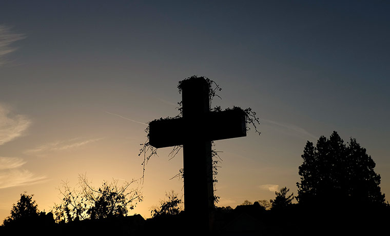 Day of the dead: Sun sets behind a cross in Vienna