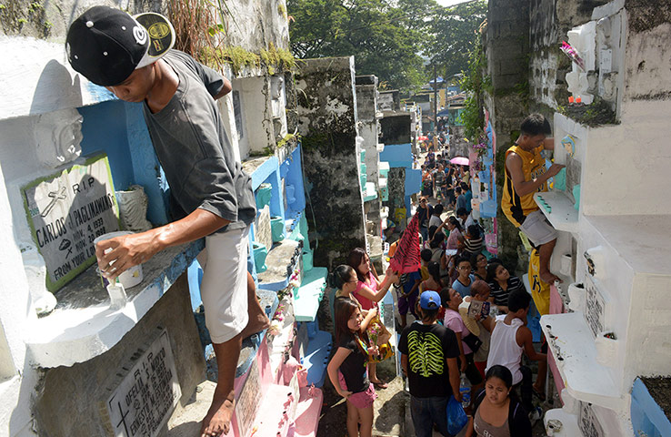 Day of the dead Workers paint tombstones in Manila