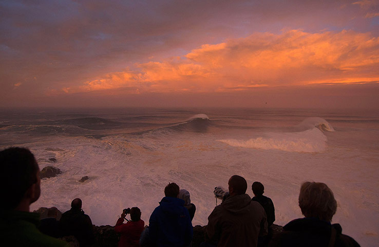20 Photos: Photographers watch the sunrise at Praia do Norte on Portugal's Atlantic coast