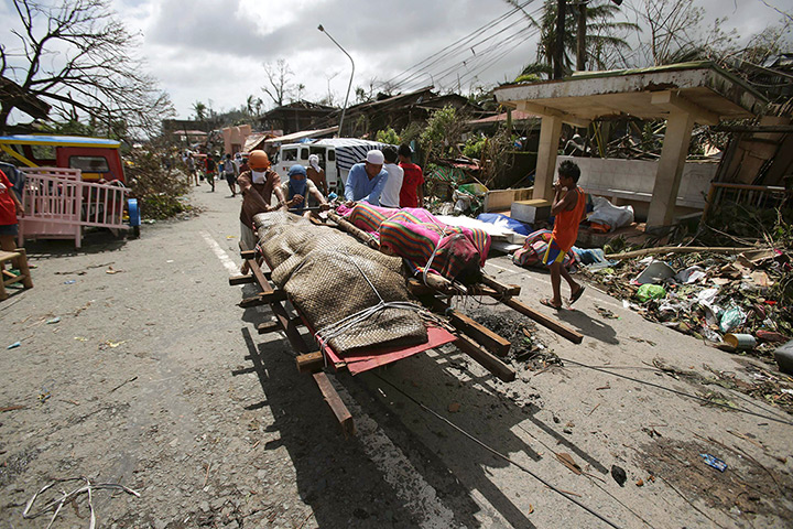 Typhoon hits Tacloban: residents push dead bodies on a cart 