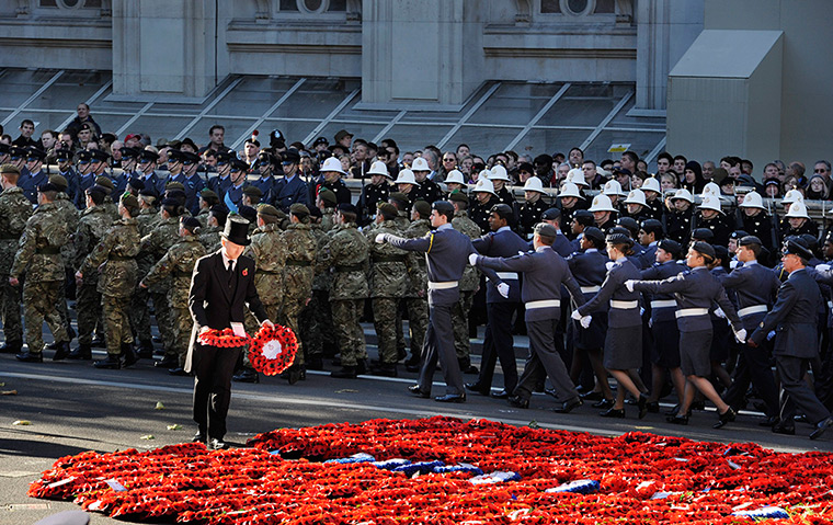Remembrance Sunday: A steward arranges poppy wreaths as servicemen and women of the armed force