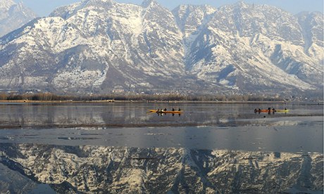 People ride boats in front of snow-cover