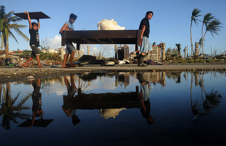 Tacloban survivors: Residents carry furniture from a hotel in Palo