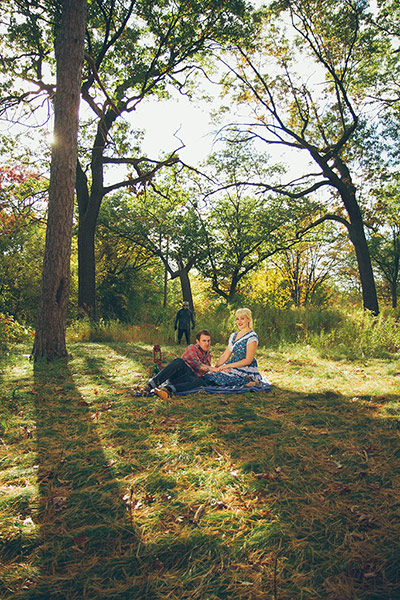 Big Picture - Friday 13th: couple sitting on grass with masked man in background