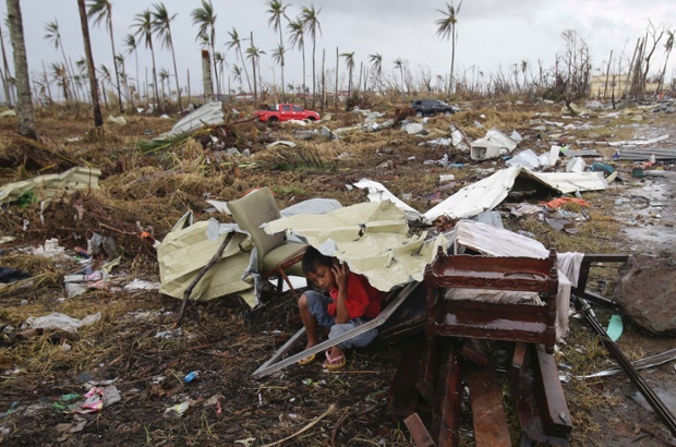 Pity this young survivor using the remains of a house as shelter from rain in Tacloban. Authorities estimated the storm may have killed 10,000 or more across the country. Click here to find out how you can help.
