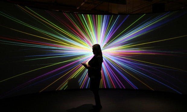 Few of us understand it but oh my, what a pretty picture it makes. An employee of the Science Museum stands in front of a video projection showing the workings of the Large Hadron Collider at the 'Collider' exhibition in London.