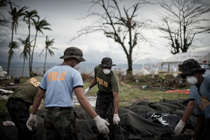 Typhoon Haiyan: Bodies are unloaded at a makeshift morgue in Tacloban
