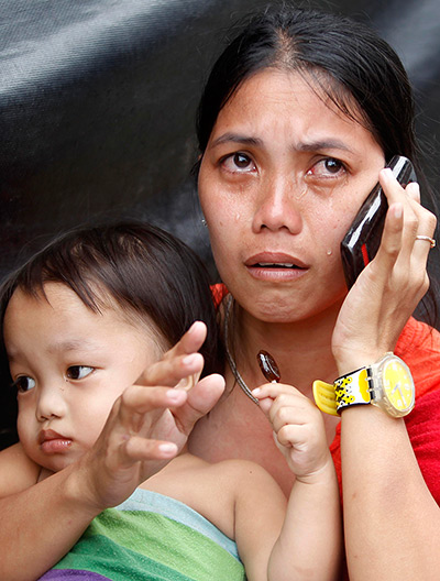 Typhoon Haiyan: A survivor who have evacuated the disaster zone, cries as she talks to her 