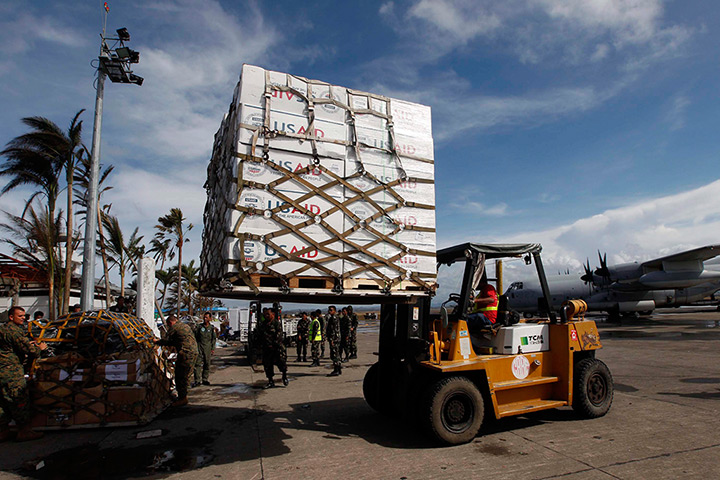 Haiyan aid: Filipino and American soldiers unload boxes of relief goods