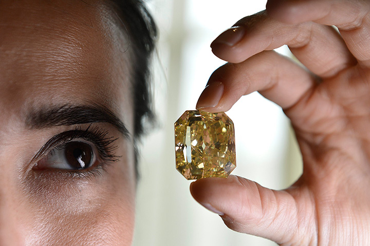 Diamonds: A Christie's employee displays a rectangular-cut fancy vivid yellow diamond