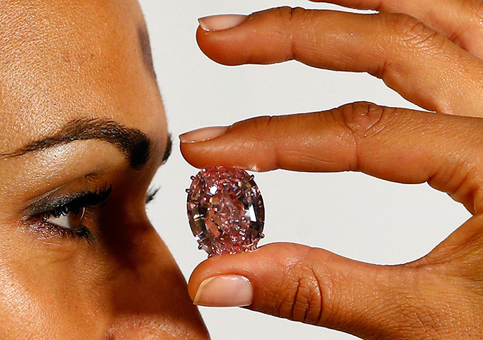 Diamonds: A model displays the Pink Star 59.60 carat oval cut pink diamond at Sotheby