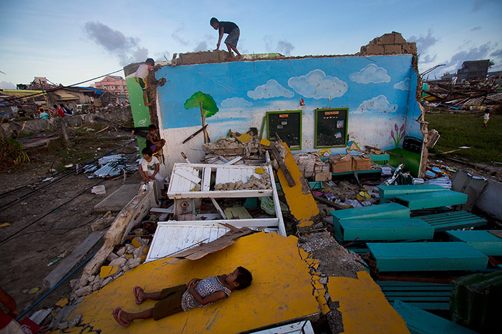 Philippines survivors: Children play on top of the ruins of their destroyed primary school in Guiu