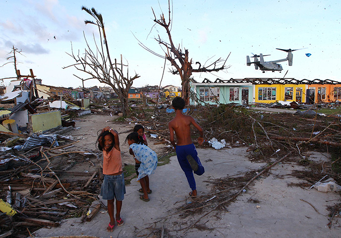 Philippines survivors: Children react as a US Marine Corps Osprey aircraft prepares to land to del