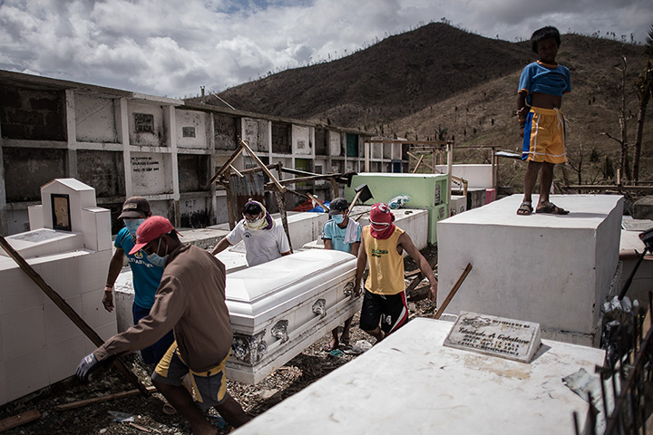 Philippines survivors: People carry the coffin of a victim into a cemetery near a mass grave site,
