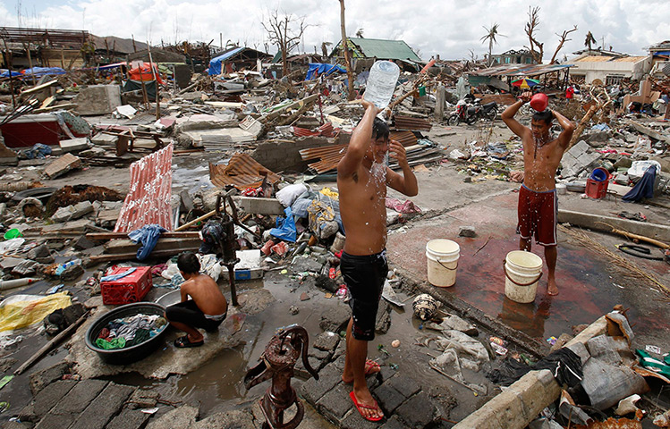 Philippines survivors: Homeless residents wash near the ruins of their houses in Tanauan, Leyte 
