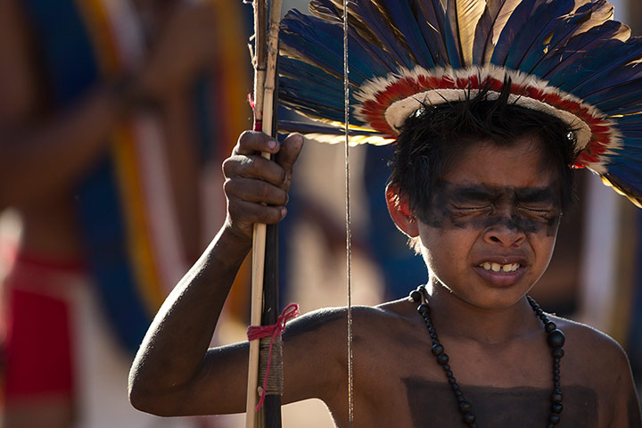 Indigenous Games: A Manoki Indian boy reacts in pain after having his nose pierced