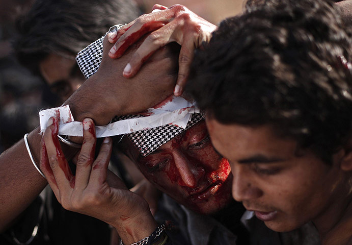20 Photos: Shi'ite Muslim men tend to a man at a Muharram procession before Ashura 