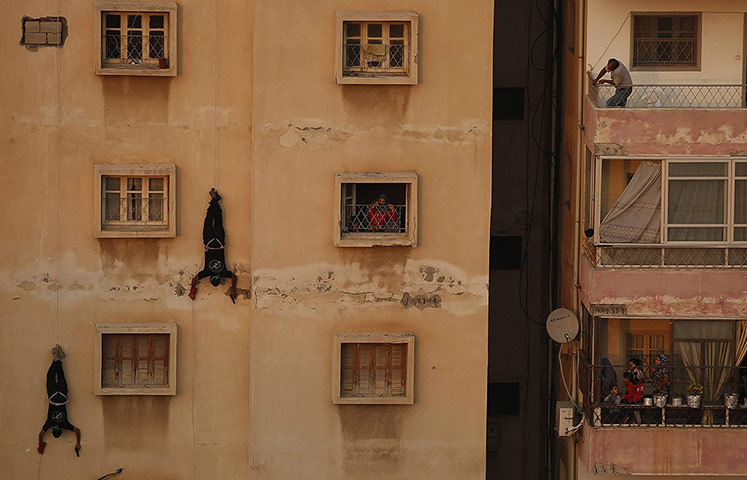 20 Photos: Palestinians look at Hamas militants as they rappel down a building in Gaza