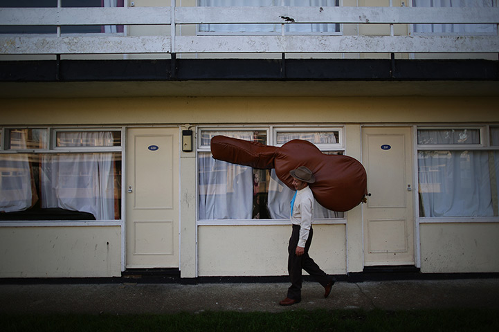 Weekend in pictures: East Sussex, UK: A member of the Zazou Cowboys carries his double bass during the Rhythm Riot event in Camber