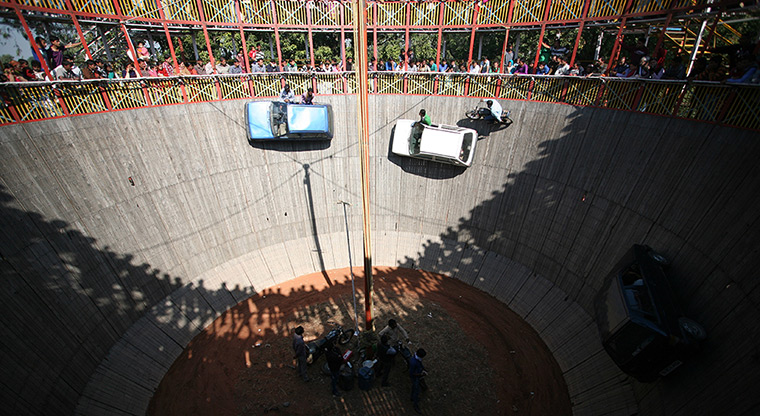Weekend in pictures: Jammu, India: Stunt performers drive vehicles in a makeshift wooden 'well of death' during the annual farmer fair