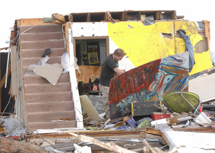 A Washington, Illinois homeowner moves debris