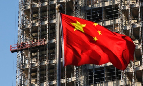 A Chinese national flag flutters at a construction site for a new residential complex in Beijing, in this November 4, 2013 file picture.