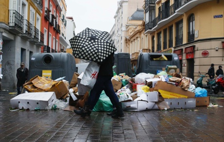 A pedestrian walks next to garbage strewn on the pavement during a strike by street cleaners in Madrid November 17, 2013.