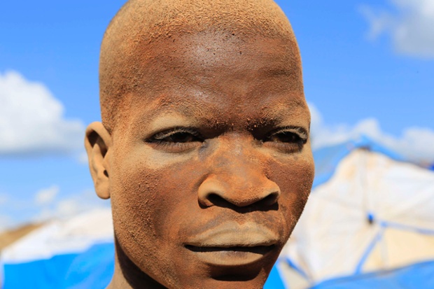 A miner is coated in dust from his day's work at an open-pit gold mine in Lukingi village in Mubende district, Uganda.