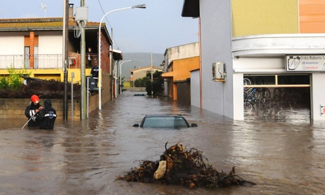 Rescuers work in a flooded street in the small town of Uras, Sardinia, Monday, Nov. 18, 2013.