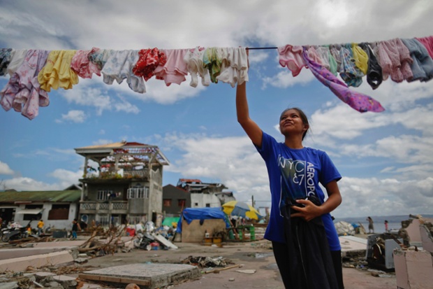 A survivor gets on with the business of daily life, hanging her washing near her destroyed home in the area of Basey, north of Tacloban.